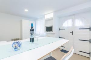 a white kitchen with a wine bottle and two glasses on a counter at Apartment Gobac in Ičići