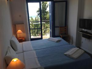 Un dormitorio con una cama grande y una ventana en Hotel Maria-Elena, en Agios Kirykos