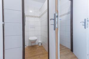 a bathroom with a toilet and a glass door at Kemp Andělská laguna Slapy in Nalžovice