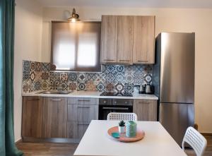 a kitchen with a table and a stainless steel refrigerator at Casa De Blue in Kariá