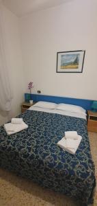 Arix Hotel في ريميني: غرفة نوم عليها سرير ووسادتين