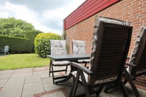 a table and chairs sitting next to a brick wall at De Zeemeeuw in Noordwijkerhout