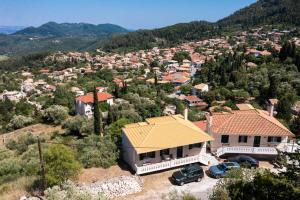 a house on a hill with cars parked in front at Casa De Blue in Kariá