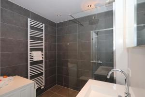 a bathroom with a shower and a sink at Holiday home de Hollandsche Tulp in Noordwijkerhout