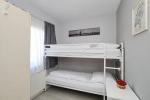 Zimmer mit 2 Etagenbetten und einem Fenster in der Unterkunft Holiday home de Hollandsche Tulp in Noordwijkerhout
