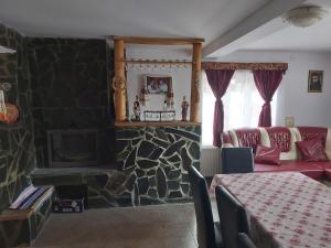 a living room with a stone fireplace and a table at Pensiunea Schilacy in Groşii Ţibleşului