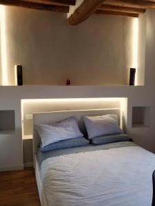 una camera con un letto bianco con due cuscini di Contemporary Rooms a San Gimignano