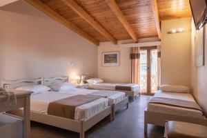 two beds in a room with wooden ceilings at Yria Hotel in Zakynthos Town