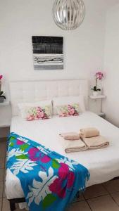 een slaapkamer met een wit bed met bloemen erop bij Apartamento Vista Lobos in Corralejo