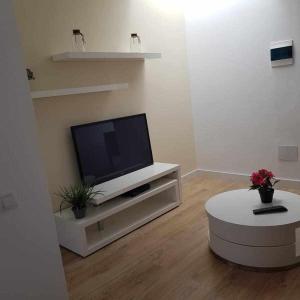 a living room with a flat screen tv and a table at Apartamento Talay 1 in Corralejo