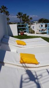 two white beds with yellow pillows on top of them at Apartamento Talay 1 in Corralejo +14 photos