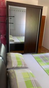 a bedroom with two beds and a mirror at Apartman Toni in Promajna