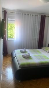 a bedroom with a bed with two towels on it at Apartman Toni in Promajna
