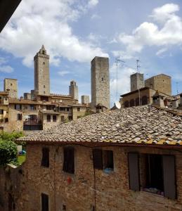 an old brick building with towers in the background at Contemporary Rooms in San Gimignano