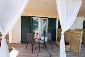 a patio with green shutters and a table and chairs at Casa De Blue in Kariá