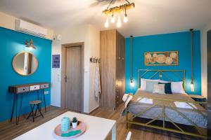 a bedroom with blue walls and a bed and a table at Casa De Blue in Kariá
