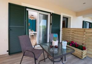 a table and chairs on a patio with green shutters at Casa De Blue in Kariá