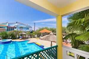 a view of the pool from the balcony of a resort at Aegean Sun Hotel in Skala Rachoniou