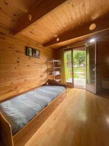 Ce lit se trouve dans un dortoir doté d'un mur en bois. dans l'établissement Les etangs de planquery, à Planquery