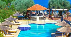 a swimming pool with chairs and umbrellas at Aegean Sun Hotel in Skala Rachoniou