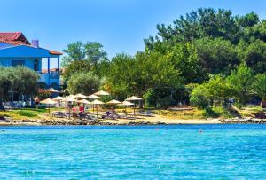 a view of a beach with umbrellas and the water at Aegean Sun Hotel in Skala Rachoniou