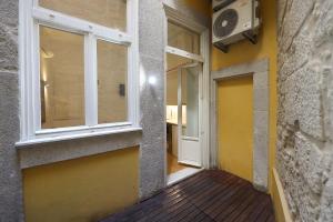 een hal van een gebouw met een raam en een deur bij FLH Porto Traditional Studio with Terrace in Porto