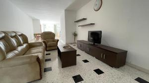 ein Wohnzimmer mit Couch und Fernseher in der Unterkunft Apartment with Private Pool in St Paul's Bay