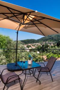 a table and two chairs under an umbrella on a deck at Casa De Blue in Kariá