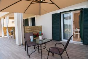 a patio with a table and chairs and an umbrella at Casa De Blue in Kariá