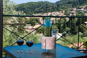 two glasses of wine on a table with a view at Casa De Blue in Kariá