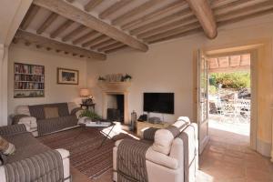 Una sala de estar con sofás y un televisor. en Villa Mareli, en Camaiore