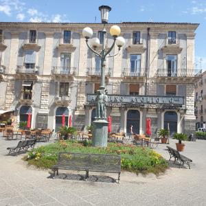 a building with a street light and a bench in front at Palazzo La Piana Rooms in Catania
