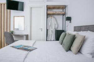 a white bed with a white suit in a room at Acropolis Vision in Athens