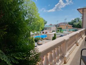 a balcony with a white railing and trees and a street at Arcadia Plaza Hotel in Odesa