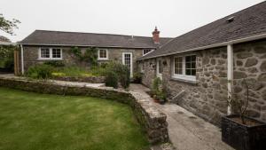a stone house with a garden in front of it at Ramblers Retreat in Helston
