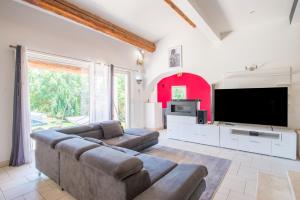Una sala de estar con un sofá y un televisor de pantalla plana. en Villa Clème, en Grignan