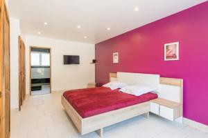 un dormitorio con una pared morada en Villa Clème, en Grignan