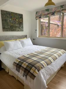 a bedroom with a bed with a plaid blanket on it at Top Studio in Lincoln