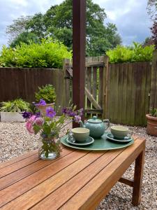 a wooden table with two cups and a vase of flowers at Top Studio in Lincoln