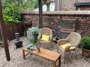 a patio with two chairs and a table and a fire place at Top Studio in Lincoln