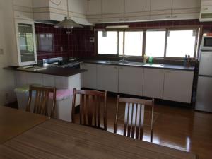 Guesthouse LARGO في أوداوارا: مطبخ مع طاولة وكراسي في مطبخ