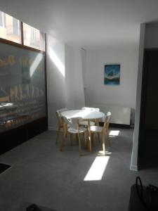 a dining room with a white table and chairs at Au P'tit Dodo in Langogne