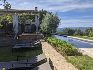 a backyard with a swimming pool and a house at Une Sieste en Luberon in Bonnieux
