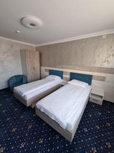 2 letti in una camera d'albergo con 2 letti sidx sidx di Vila El Passo a Târgu-Mureş