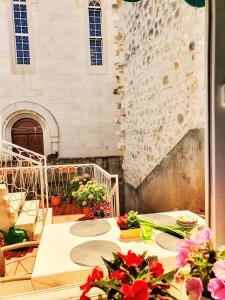 a patio with tables and flowers in front of a building at Heart of the City Apartments in Dubrovnik