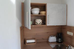 a kitchen with a cupboard with dishes in it at Ferienhaus Bayerwald in Ringelai