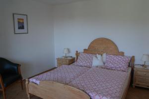 a bedroom with a bed with a wooden headboard and pillows at Ferienhaus Bayerwald in Ringelai