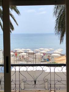 Blick auf einen Strand mit Sonnenschirmen und das Meer in der Unterkunft Hotel Solemare in Albenga