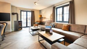 a living room with a couch and a fireplace at UplandParcs Winterberg in Winterberg