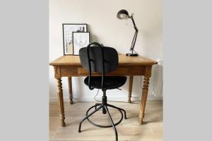 Un escritorio con una silla negra y una lámpara. en Le Clémenceau, en Hyères